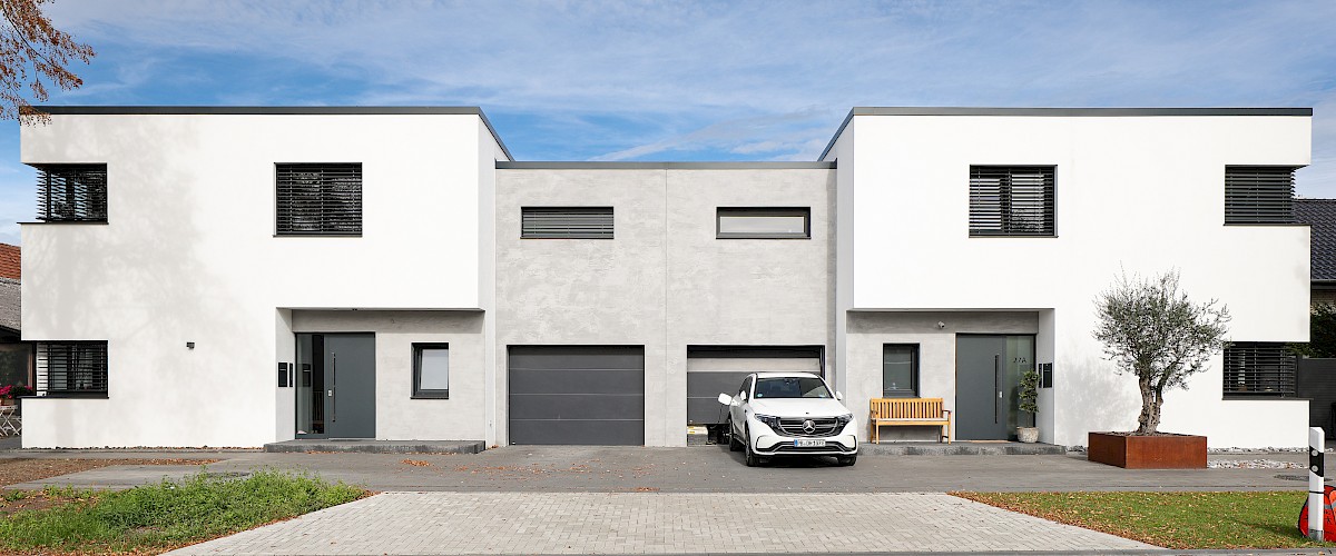 Modernes Doppelhaus im Bauhausstil mit Flachdach und Wärmedämmverbundsystem